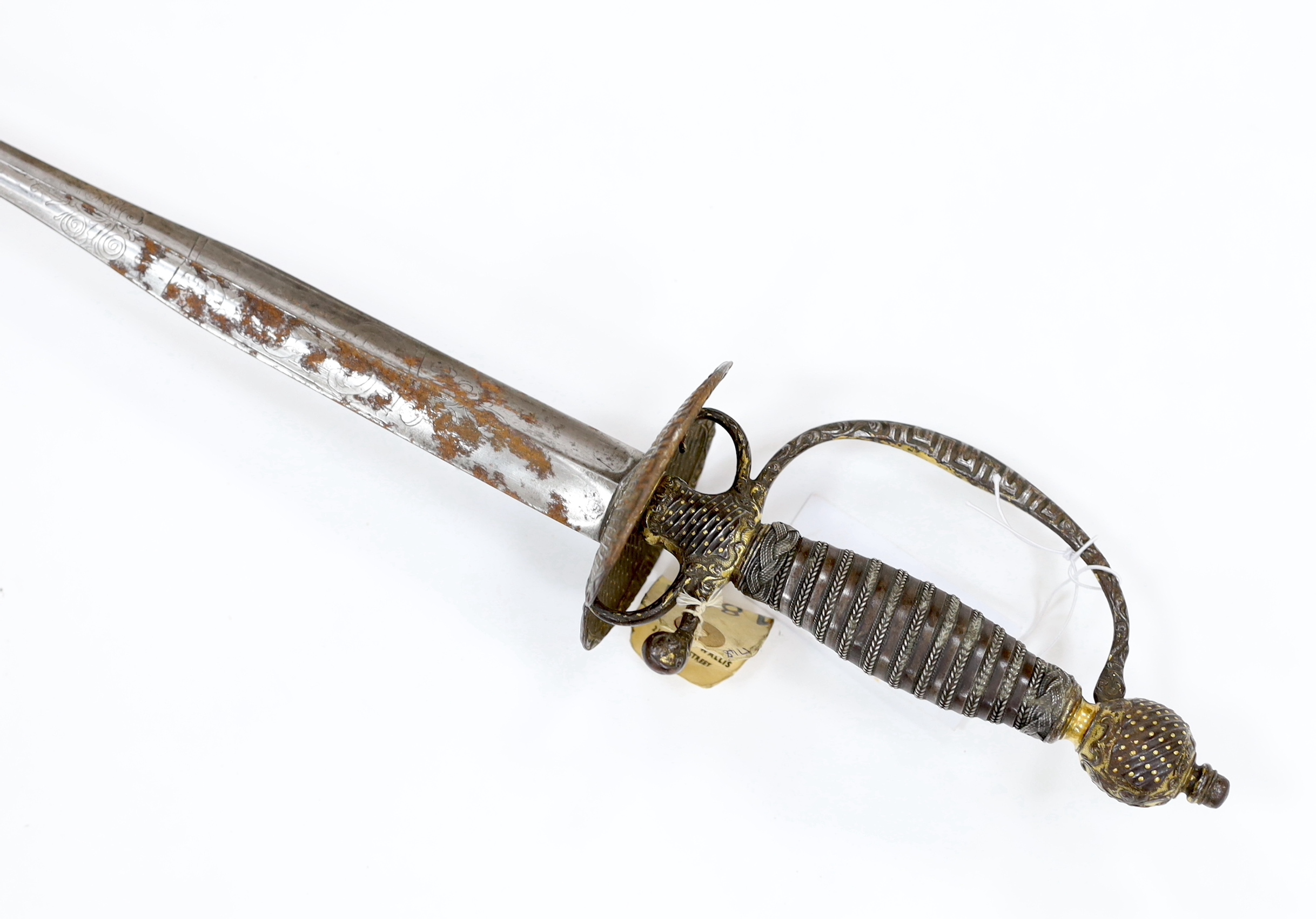 A French iron hilted small sword, hilt with flutes and tiny gold dots, the knuckle guard with key decoration, iron tape and silver wire bound grip, colichemarde blade with etched strapwork decoration, c.1770, blade 83cm